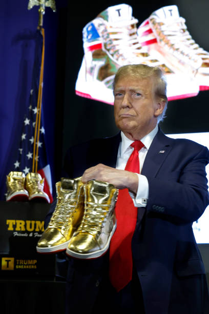 Republican presidential candidate and former President Donald Trump holds a pair of his new line of signature shoes